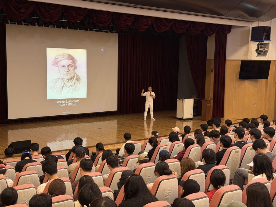 스크린에 겐리히 알트슐러의 초상이 띄워진 강연 장면